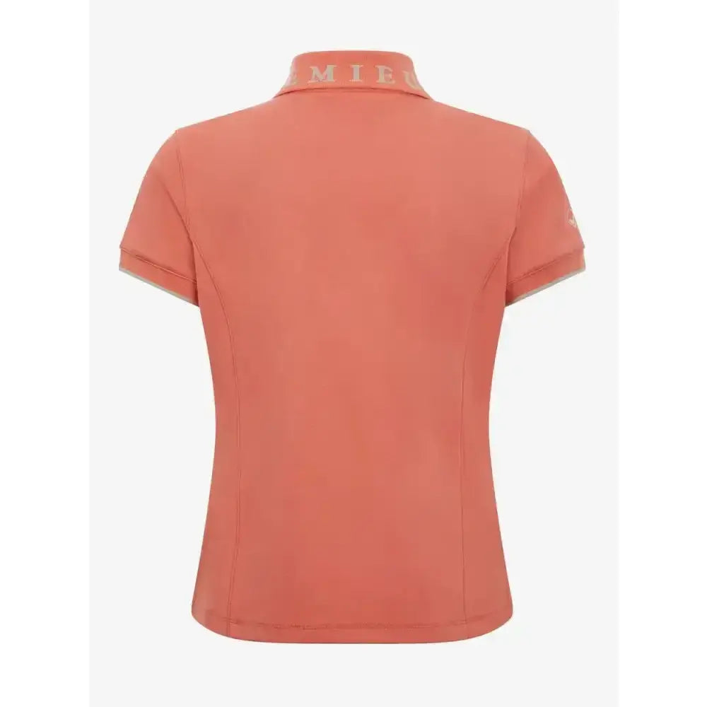 Coral-colored lemieux young rider polo shirt with jacquard rib collar and subtle logo on collar and sleeve