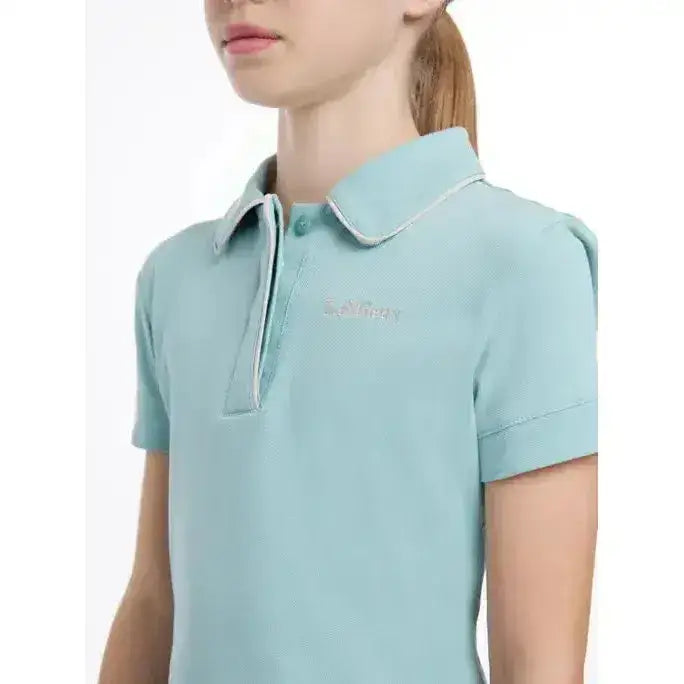 Light blue lemieux young rider polo shirt with subtle textured weave and white piping on collar and cuffs
