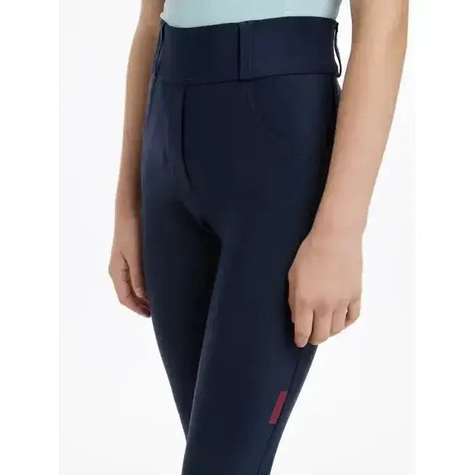 Navy blue lemieux young rider remi breggings with subtle pink logo on side seam perfect for young riders