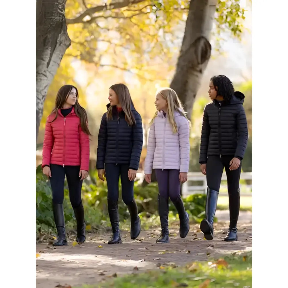 Four young women wearing lemieux young rider ruby puffer jackets in black pink light purple and dark gray walking outdoors