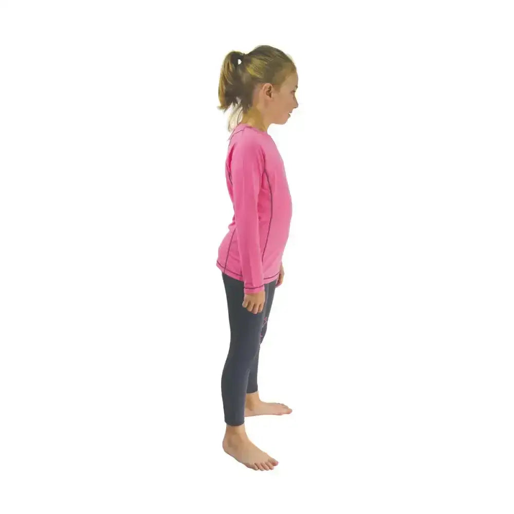 A young girl wearing a vibrant pink long-sleeved little rider base layer top perfect for active child riding apparel