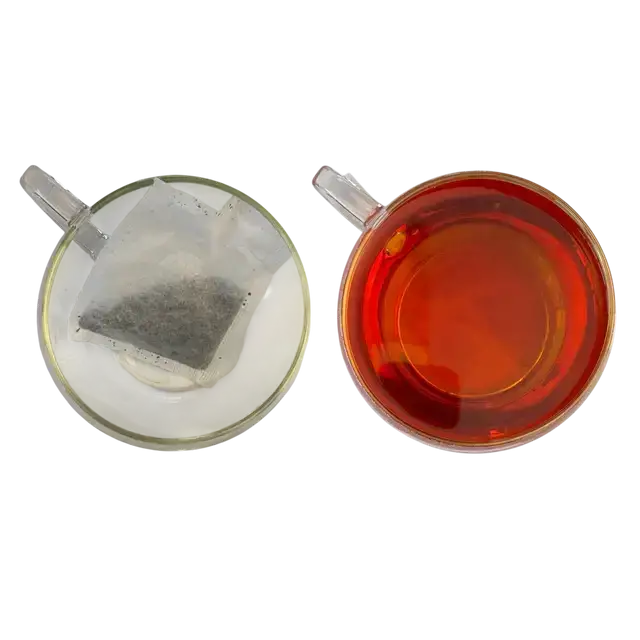 Clear glass teacup with amber miles tea decaffeinated teabags and unbrewed tea bag from west country