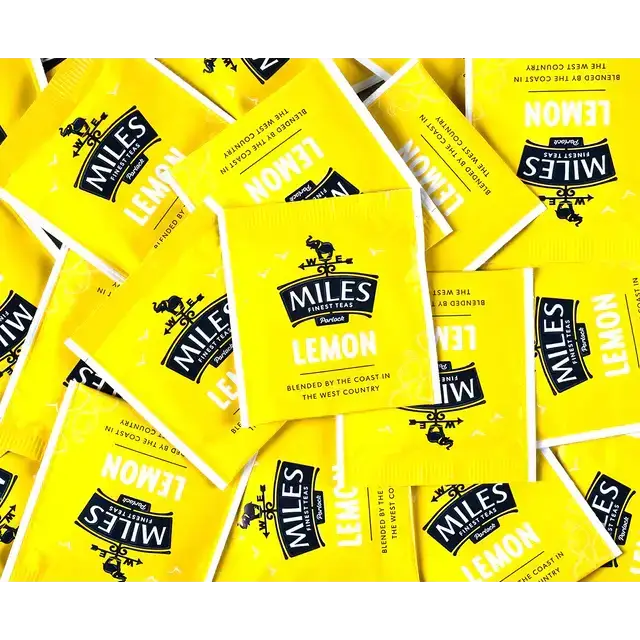 Bright yellow miles tea lemon envelope teabags with a black logo on glossy lemon verbena packaging