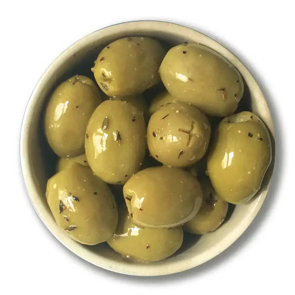 A bowl of organic lemon thyme and black pepper green olives speckled with herbs and glistening with brine