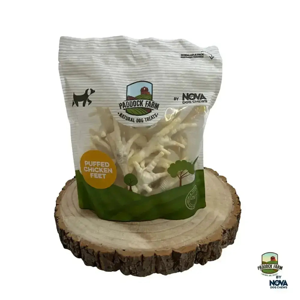 A white and green striped bag of paddock farm puffed chicken feet dog chews featuring puffed chicken feet treats
