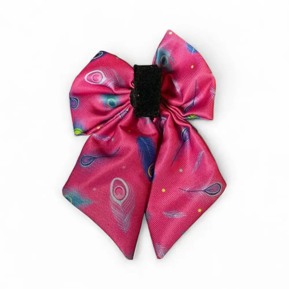 A bold beautiful peacock power sailor bow in vibrant pink satin with secure elastic loops and peacock feather pattern accents