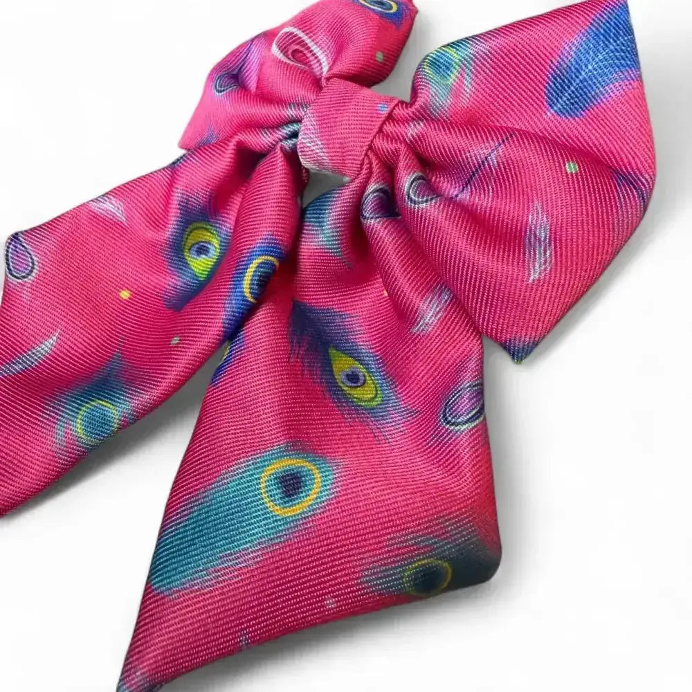 A bold beautiful pink satin peacock power sailor bow with secure elastic loops and a playful peacock eye pattern