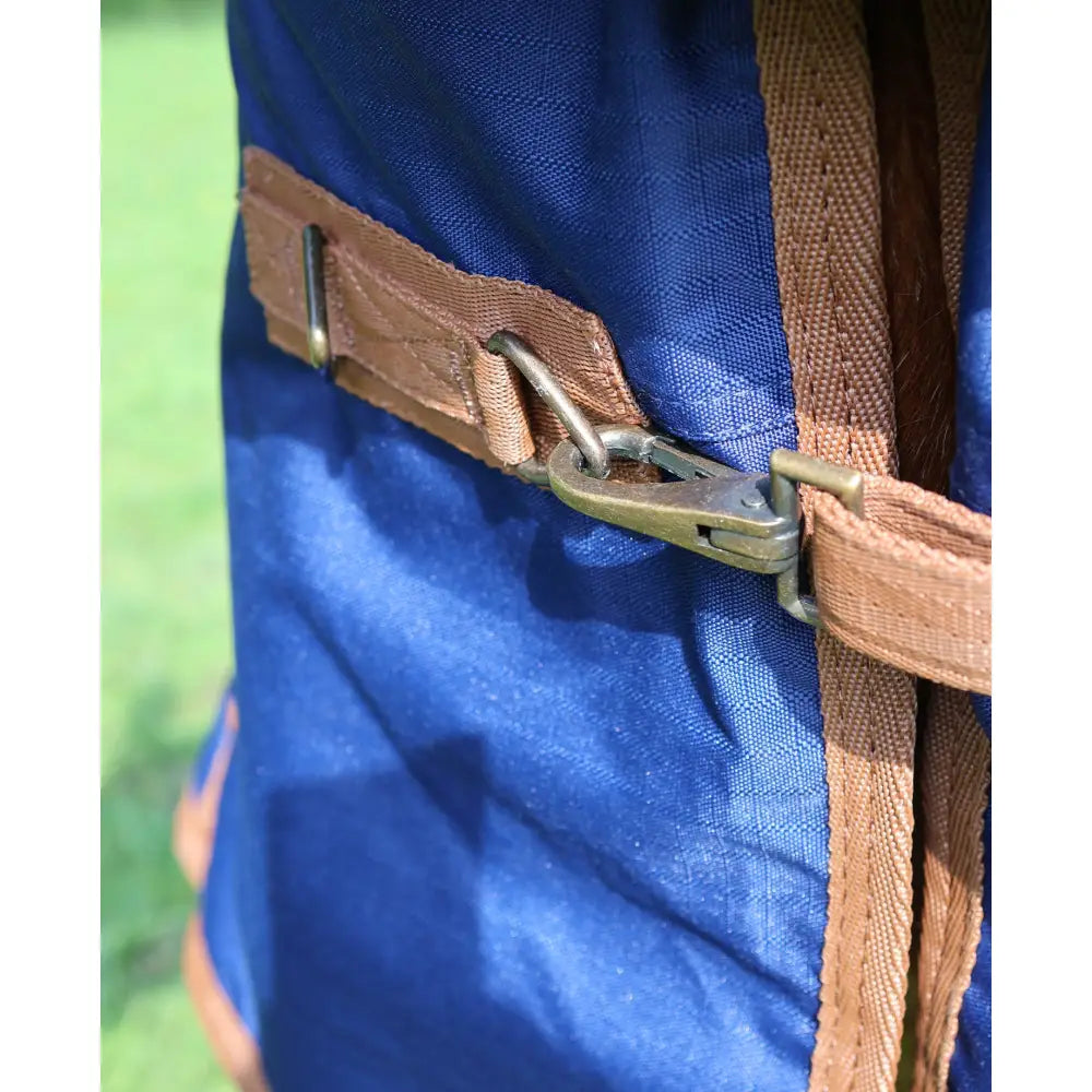 Blue canvas backpack with tan webbing straps and brass buckle shown with perf standard 100g lightweight turnout rug