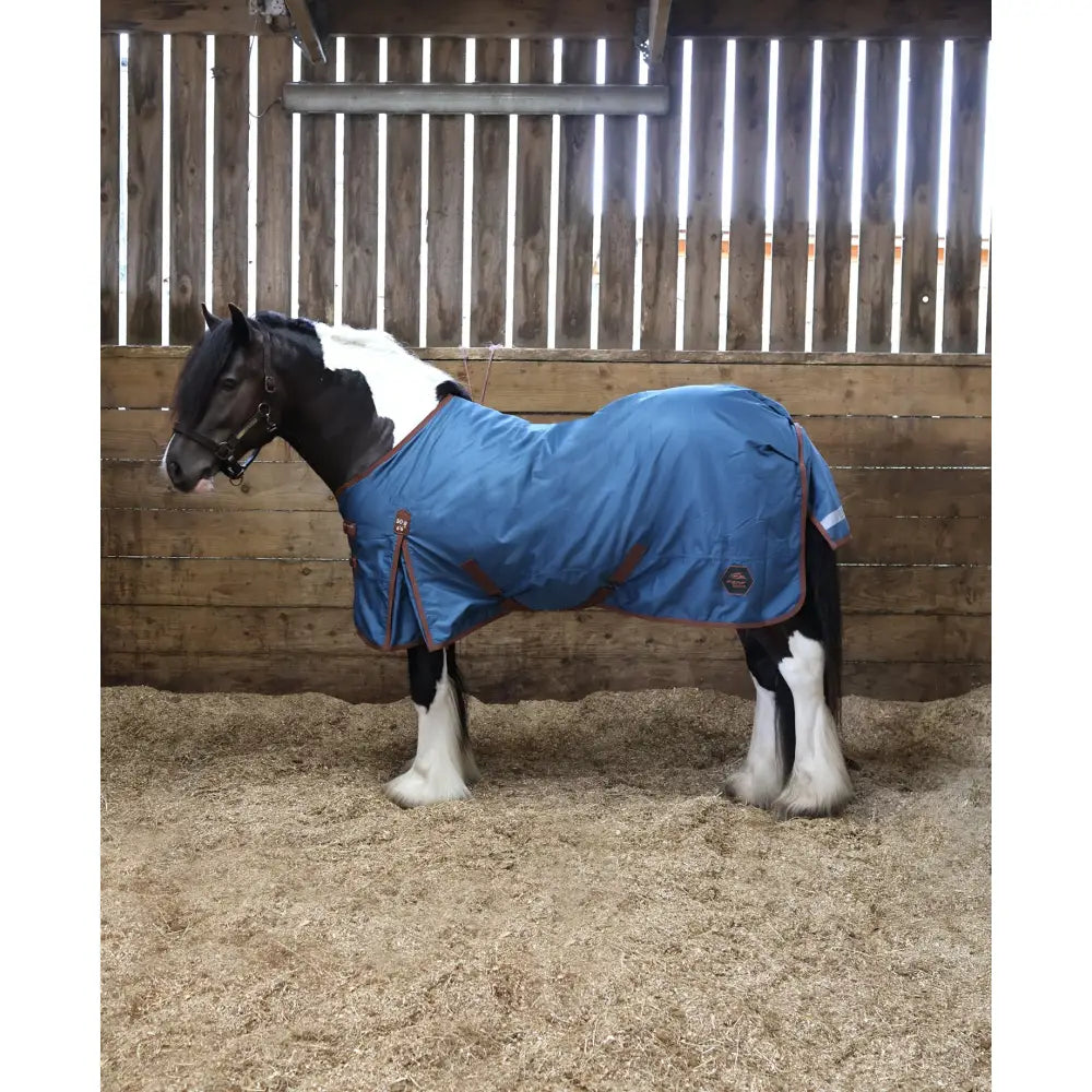 Blue perf standard 50g lightweight turnout rug for horses with brown trim and small circular logo on the side