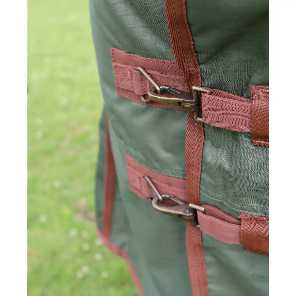 Dark green canvas perf standard 50g lightweight turnout rug with rust webbing straps and brass metal buckles for horses