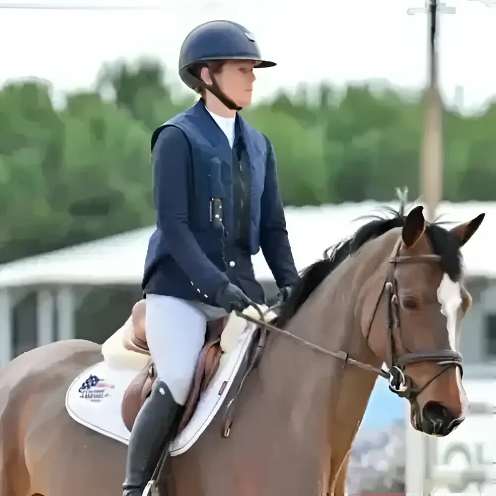 A brown horse with a white blaze wearing a bridle and saddle showcasing point two hunter pro air body protector for kids