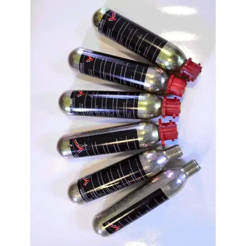 Six silver point two replacement co2 canisters with black labels and red caps arranged diagonally for proair use