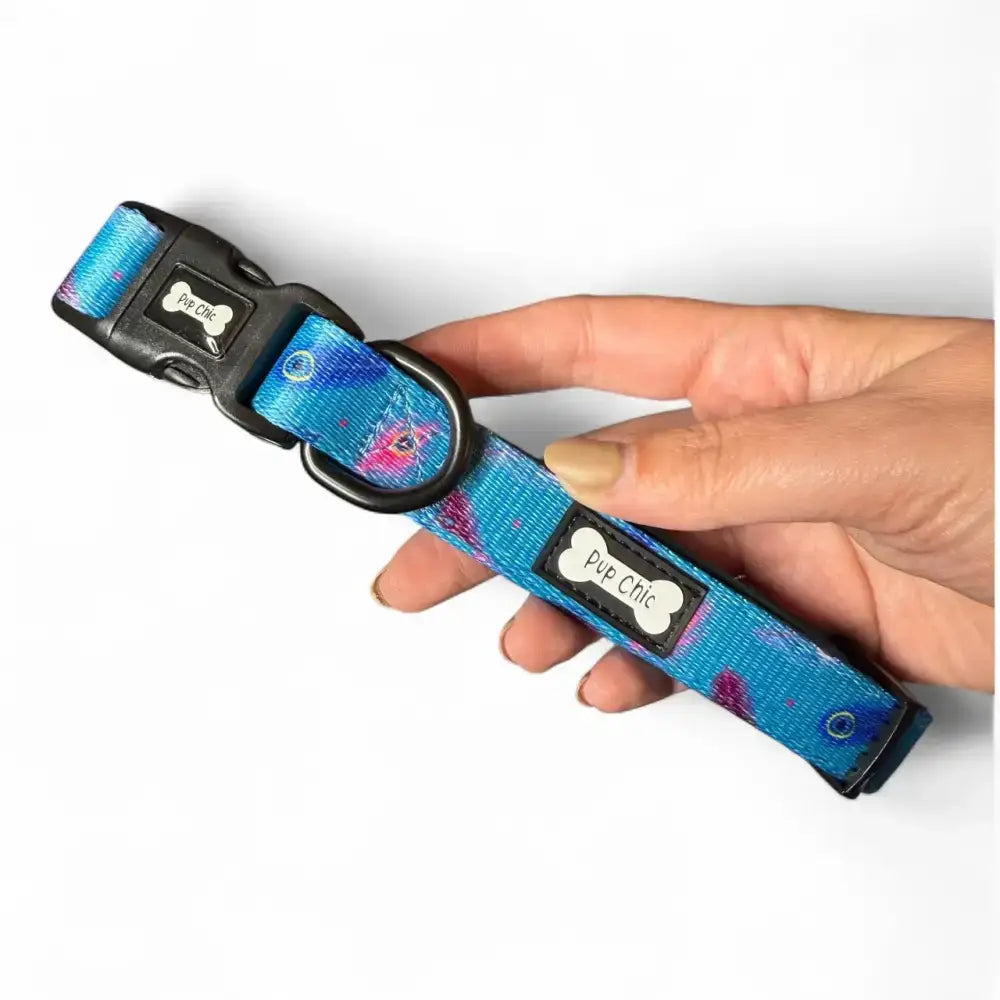 A vibrant blue and purple tie-dye strong large tactical dog collar with black hardware and pup chic bone label from power peacock dog