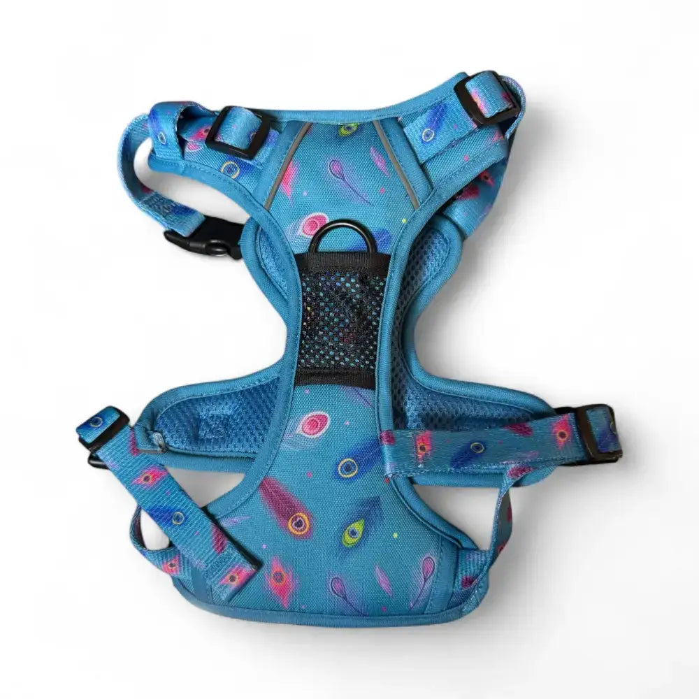 A vibrant blue peacock power tactical dog harness with pink green and purple feathers and black buckles fully adjustable