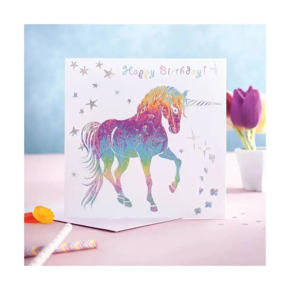 A vibrant prancing myth card featuring a rainbow happy birthday unicorn head with silver stars and happy birthday text