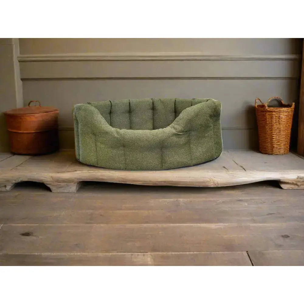 A plush olive-green premium orkney tweed tweed oval bed with soft fabric rounded edges and a 7cm base