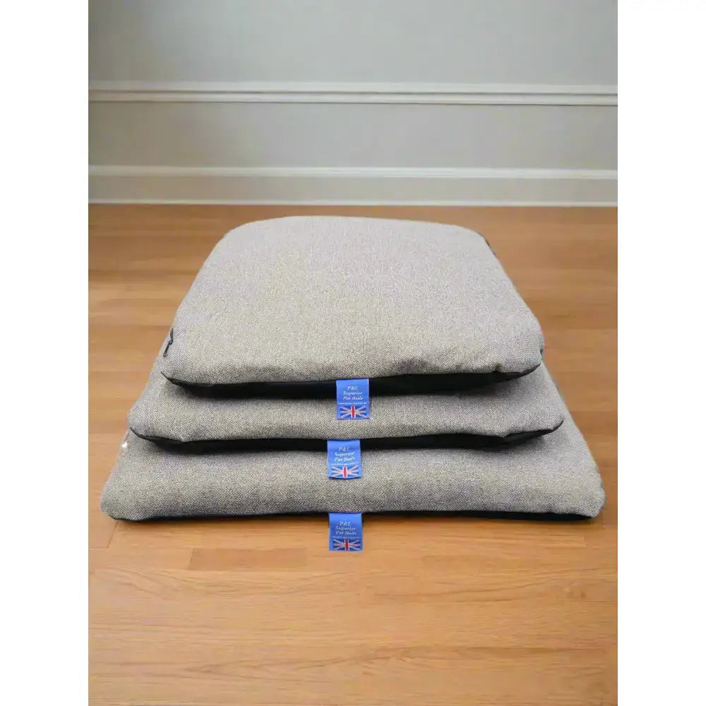 Stacked gray woolen pet beds with blue union jack tags featuring premium orkney tweed removable cover duvet