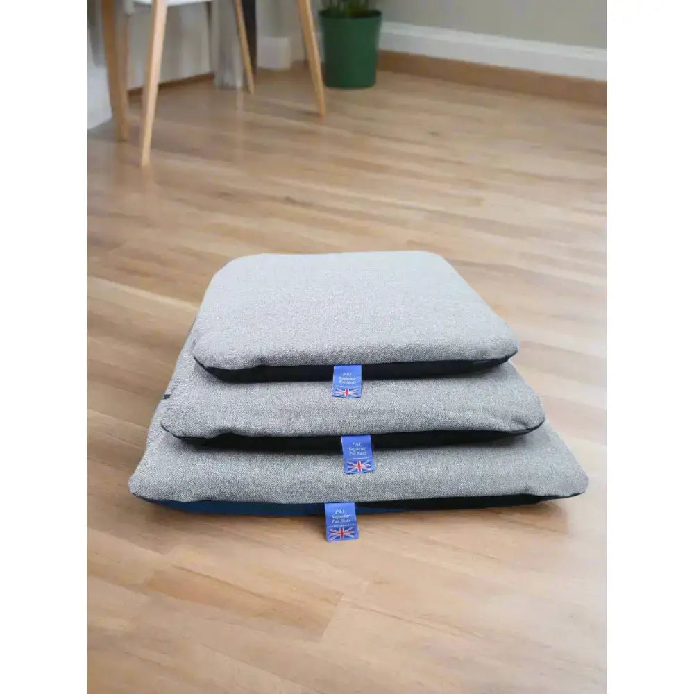 Stacked gray pet beds with navy blue trim and union jack tags featuring premium orkney tweed removable cover duvet