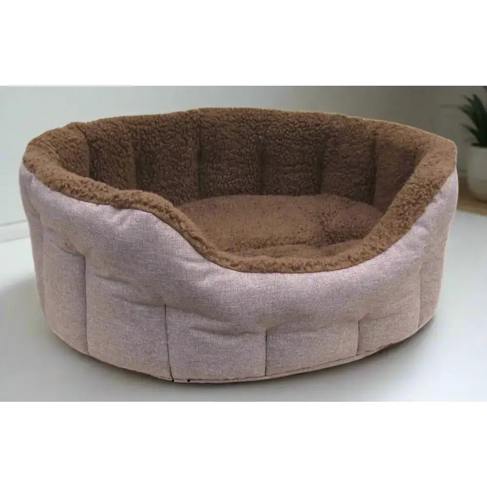 A premium oval bolster style heavy duty fleece lined dog bed with pink outer fabric and soft brown fleece lining
