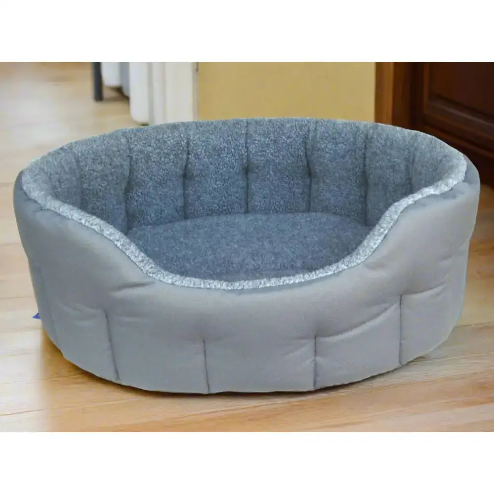 Gray tufted premium oval bolster heavy duty fleece lined machine washable dog bed with plush interior and silver trim