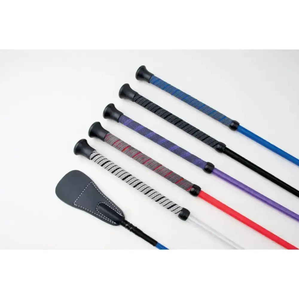 Set of five colorful rhinegold grip handle riding crops with textured wraps and a black leather saddle pad