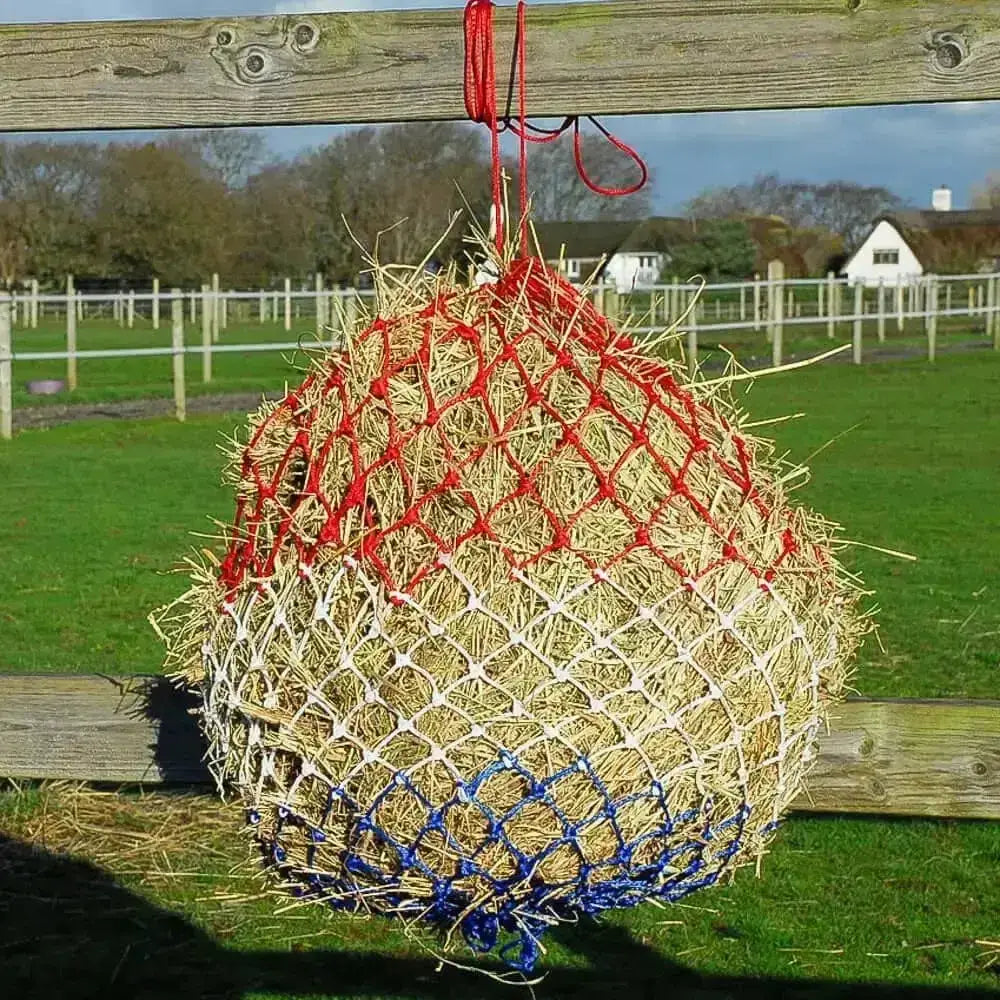 A round rhinegold monarch slow feeder haynet with red white and blue netting designed for slow feeding hay