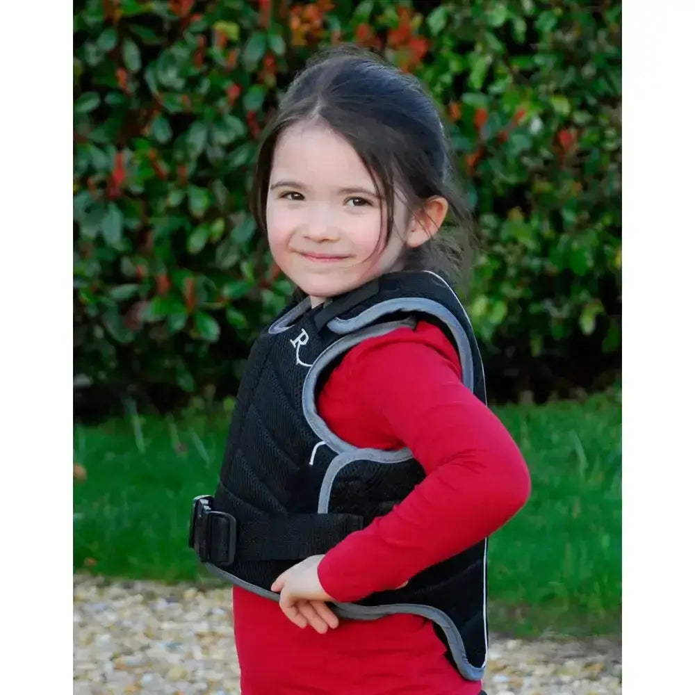 Black and gray padded rhinegold pro comfort childs body protector beta with white r logo on shoulder for safety