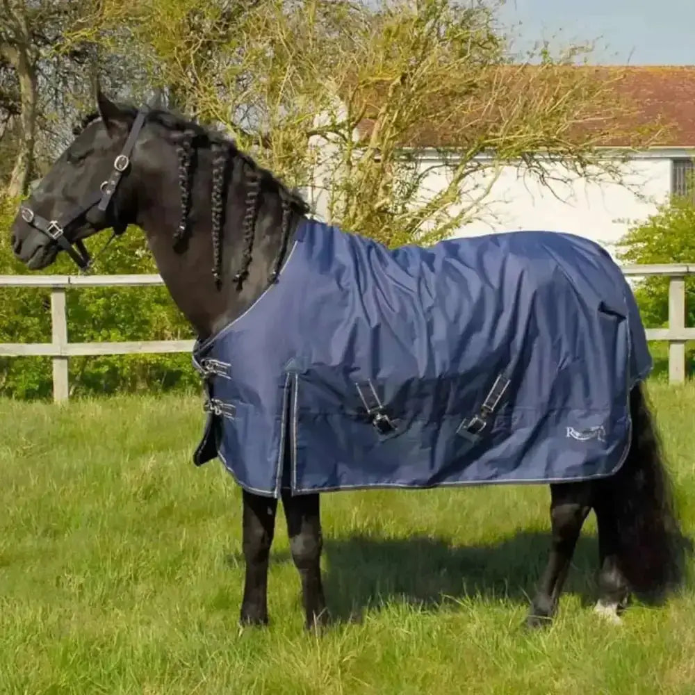 A navy blue rhinegold torrent turnout lightweight turnout rug with silver buckles and stitching for horses