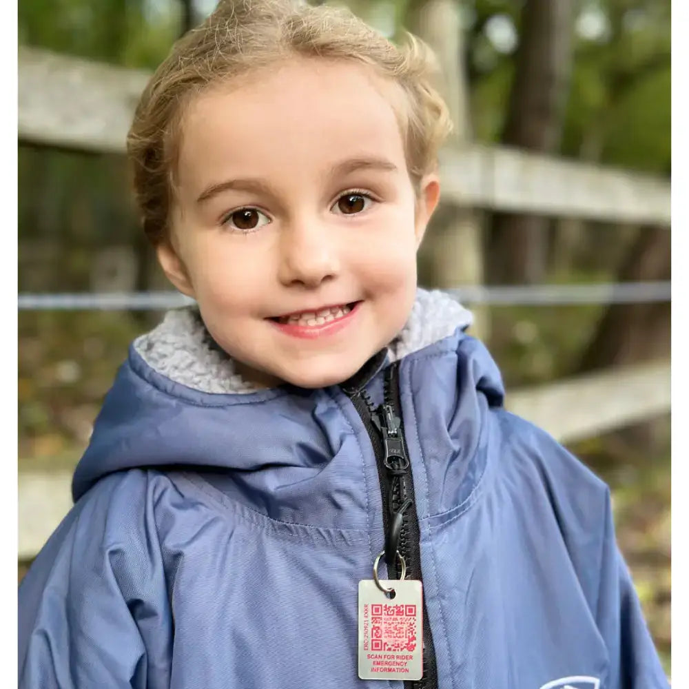Blue waterproof rider emergency tag jacket with gray fleece hood, black zipper, and white emergency contacts qr code tag