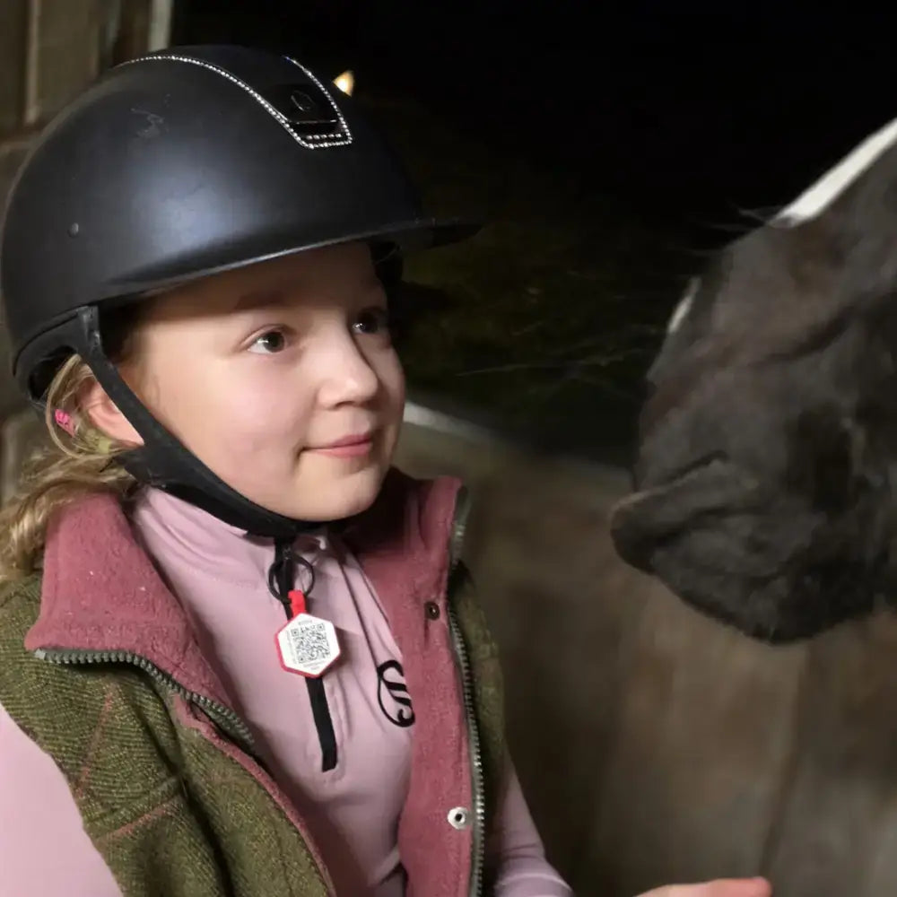 Black equestrian helmet with subtle silver trim and small logo designed for rider emergency tag enduro safety use