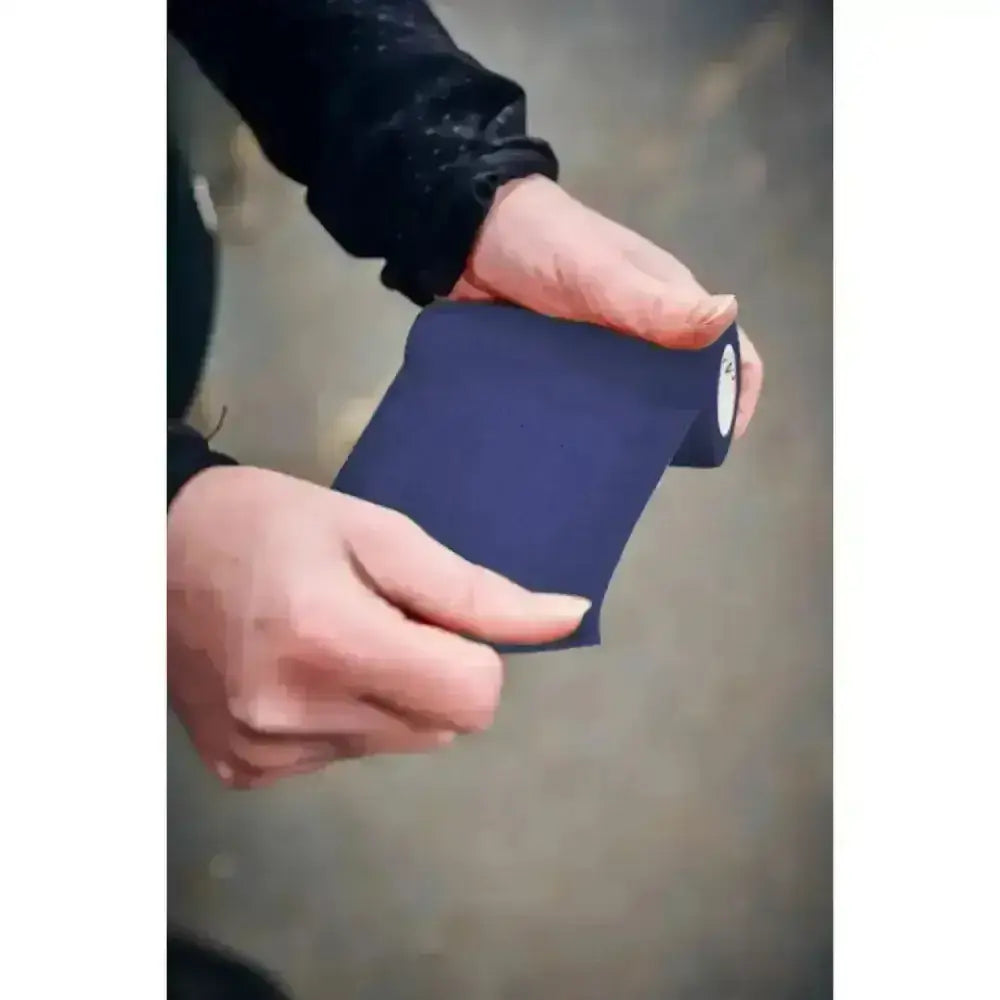 Dark blue athletic tape rolled and held in hands showing robinsons healthcare equiwrap bandage vet wrap robinsons