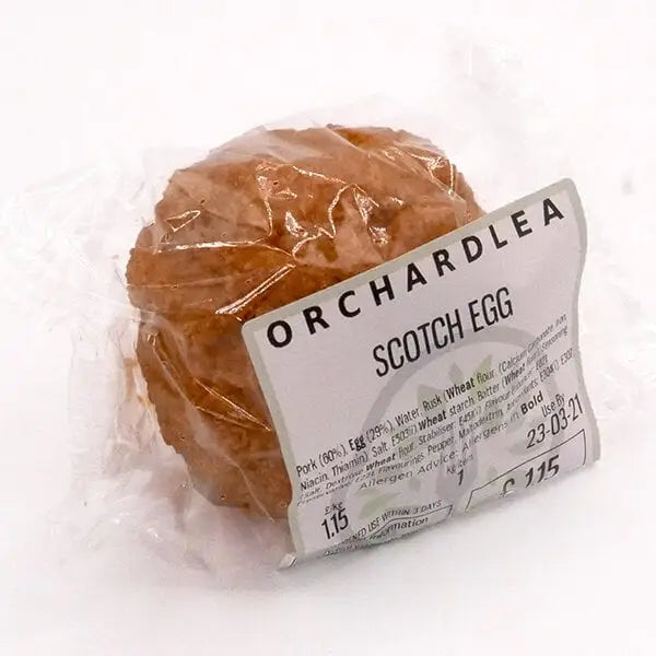 A golden-brown round scotch egg wrapped in clear plastic with orchardlea label perfect for chunk squealer fans