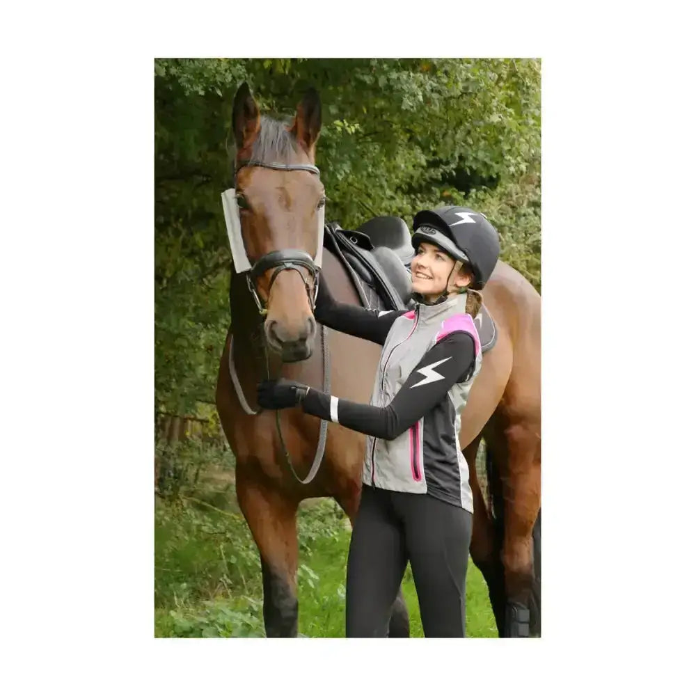 Black equestrian helmet with white lightning bolt logo paired with silva flash lightweight duo reflective gilet by hy equestrian