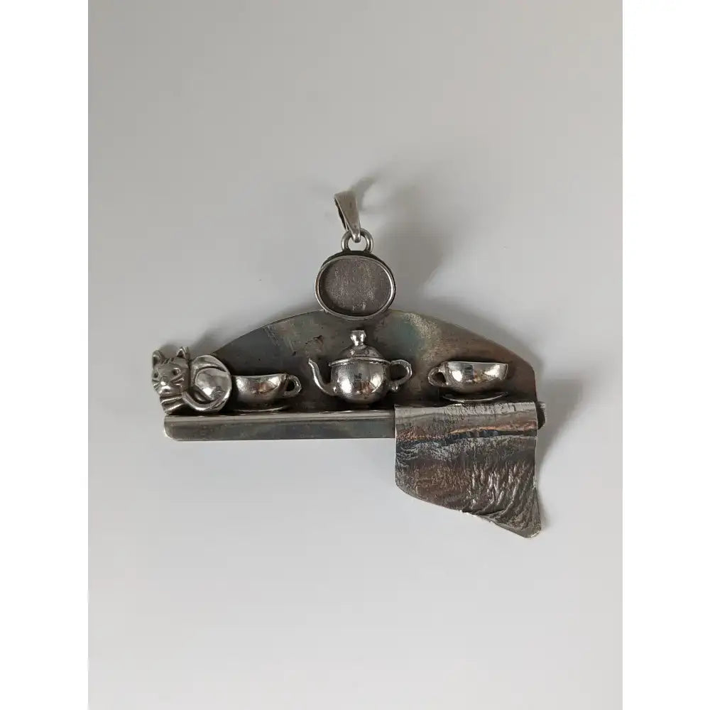 Silver steed cats shelf silver pendant featuring a metallic silver teapot and cup set with a cat figurine charm