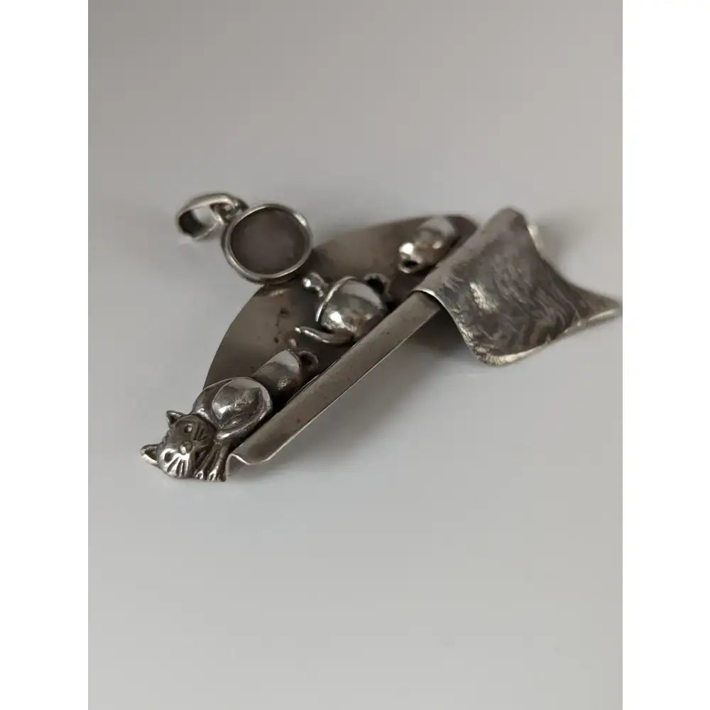 Silver steed cats shelf silver pendant featuring a silver-toned whimsical design of teapots cups and a cat on a curved base