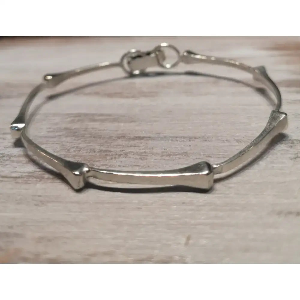 Silver steed sterling silver hoofnails bangle with a sleek minimalist bone-shaped bracelet design and polished finish