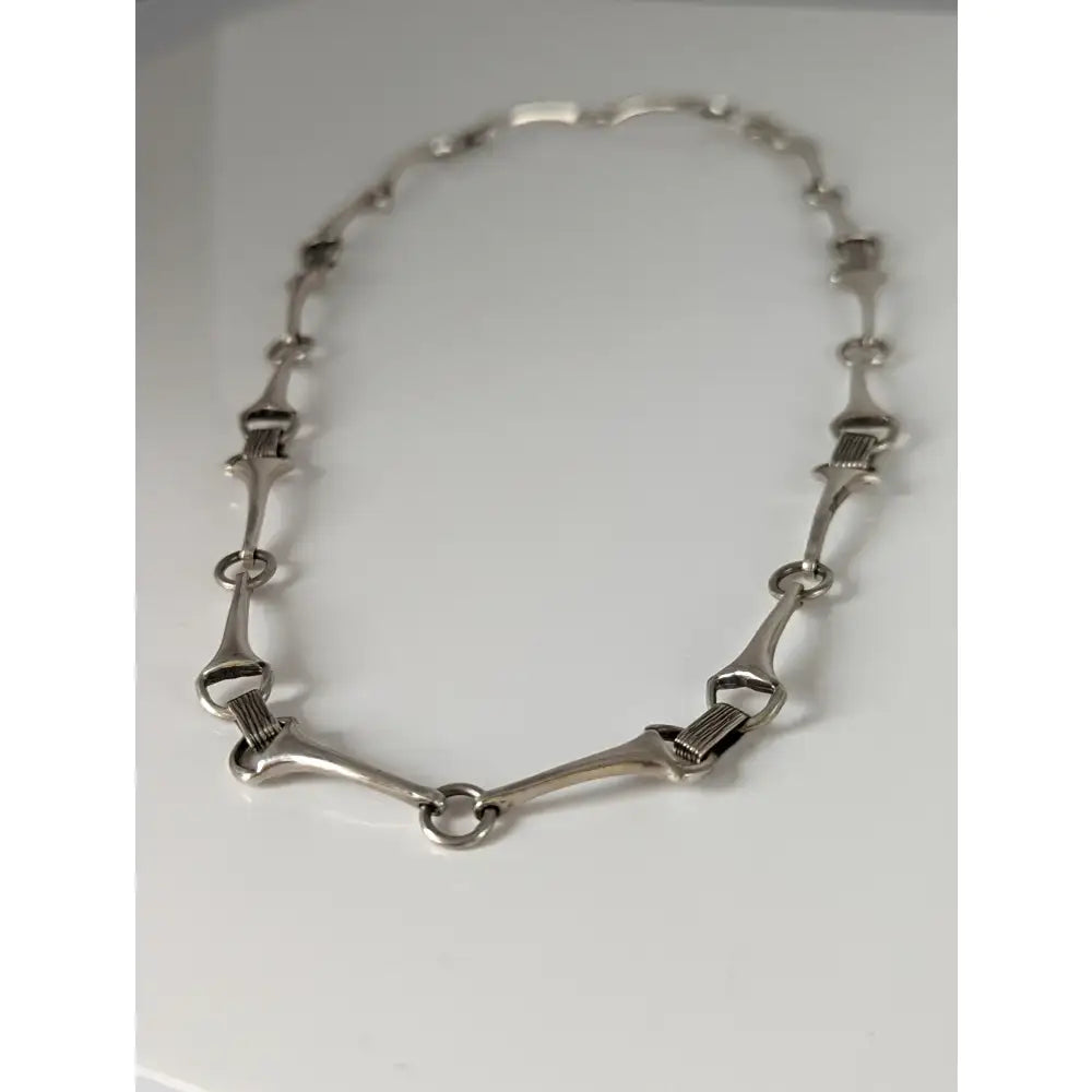 Silver steed snaffle necklace features quality silver with a sleek polished horsebit design and interlocking links