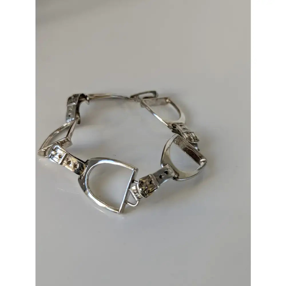 Silver steed stirrups bracelet with polished silver horsebit links and intricate equestrian design details