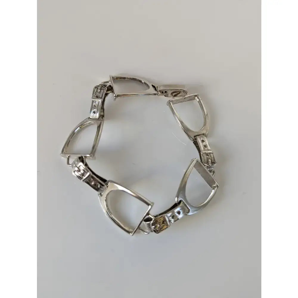 Silver steed stirrups bracelet featuring a silver horsebit design with clear and yellow gemstones in an equestrian style