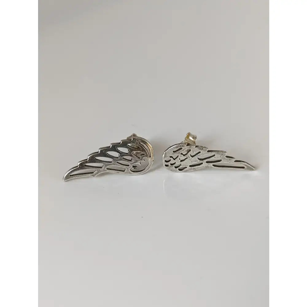 Silver steed angel wings stud earrings with intricate cut-out detailing and polished metallic finish in silver