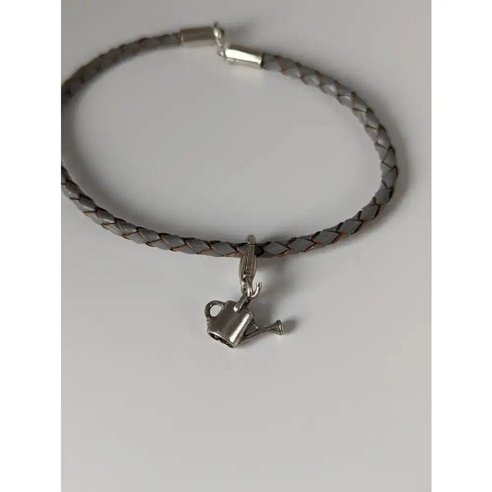 Gray braided leather cord bracelet with silver-toned watering can charm from silver steed assorted charms collection