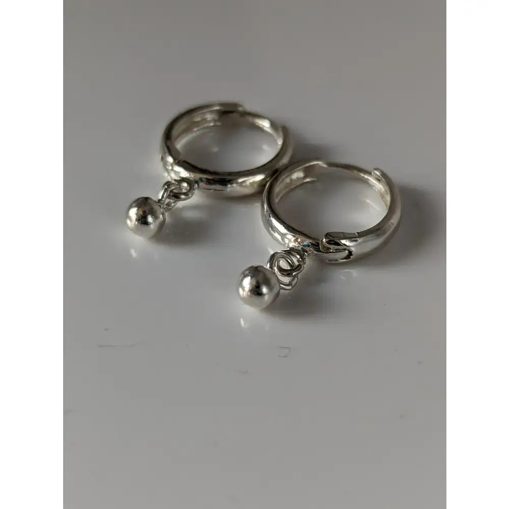 Silver steed ball hoop earrings feature silver hoops with small spherical charms perfect for everyday wear