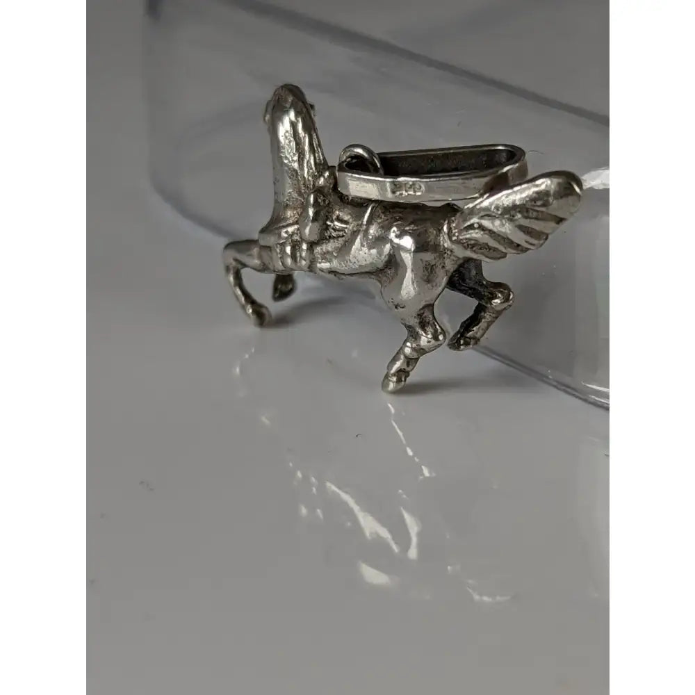 Silver steed carousel horse silver pendant in silver metal with detailed wings, rider, and rectangular loop for attachment