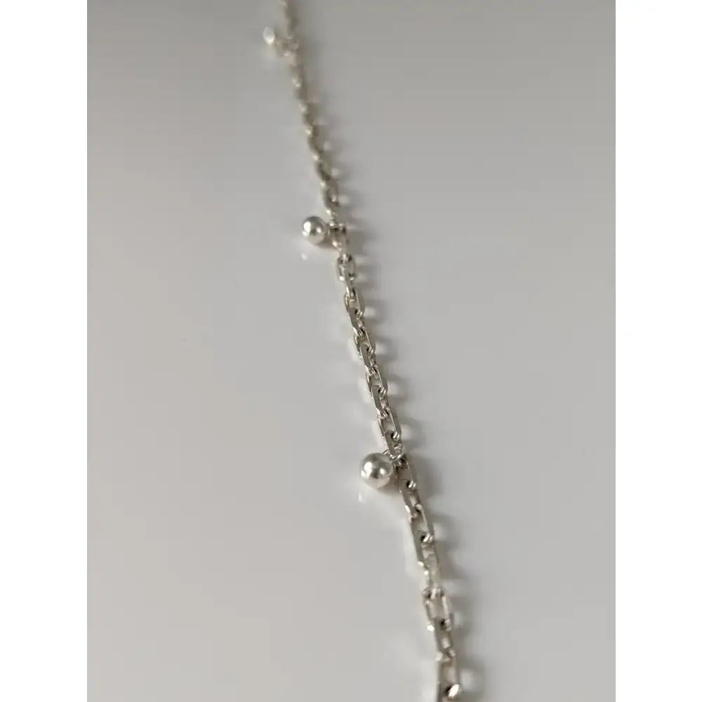 Silver steed chain silver bracelet with ball charms and small spherical beads spaced along the silver chain anklet