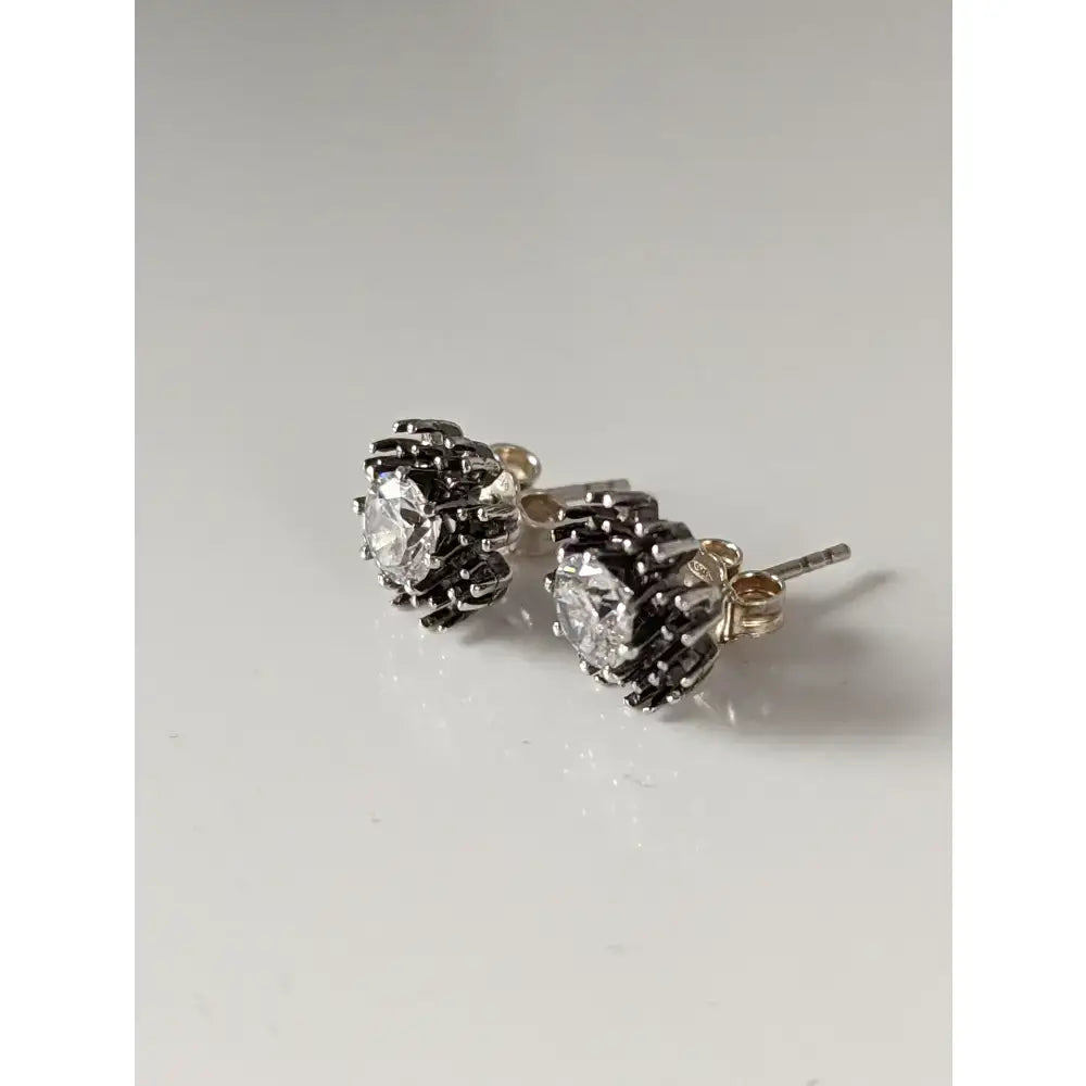 Silver steed crystal sunflower stud earrings with clear gemstone center and black stones in floral design