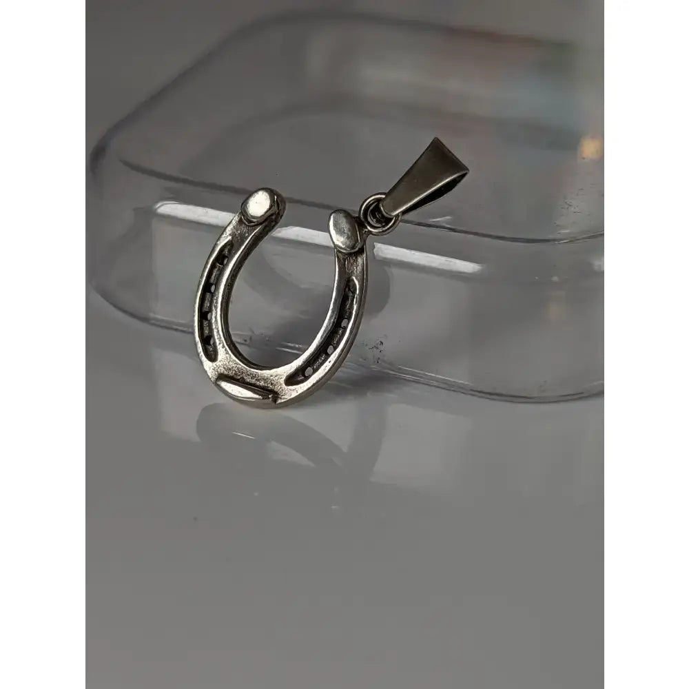 Silver steed pendant horseshoe jewelry with polished metallic finish and detailed nailhead texture in equestrian silver