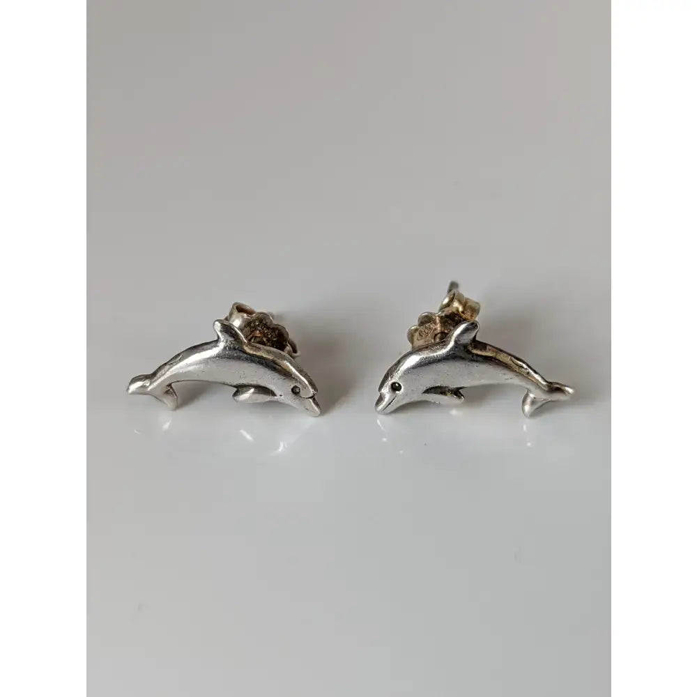 Silver steed dolphin stud earrings with polished metallic finish and detailed silver dolphin design