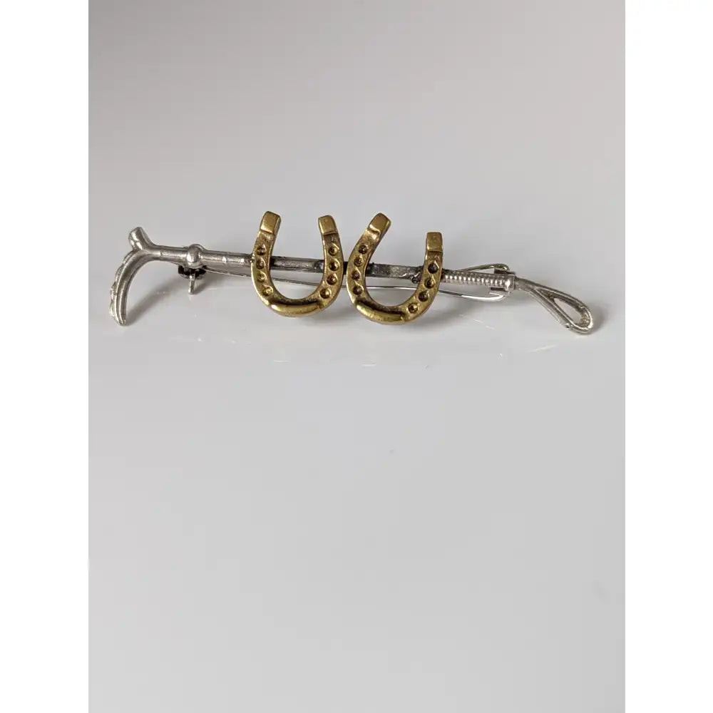 Silver steed double shoe and cane brooch featuring a sleek handmade silver and gold horse hoof tie clip