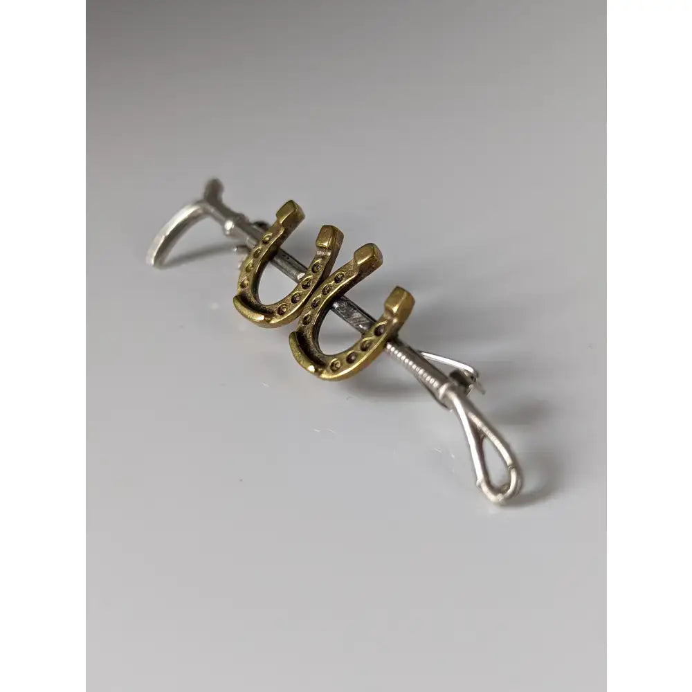 Gold-colored horseshoe bar pin with silver-toned clasp, part of the silver steed double handmade silver cane brooch collection