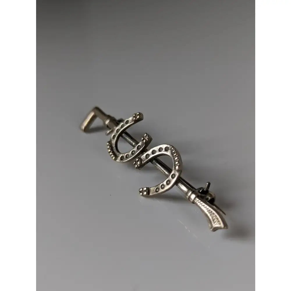 Silver steed double shoe silver brooch is a silver-colored metal stock tie pin shaped like three horseshoes with dotted detailing